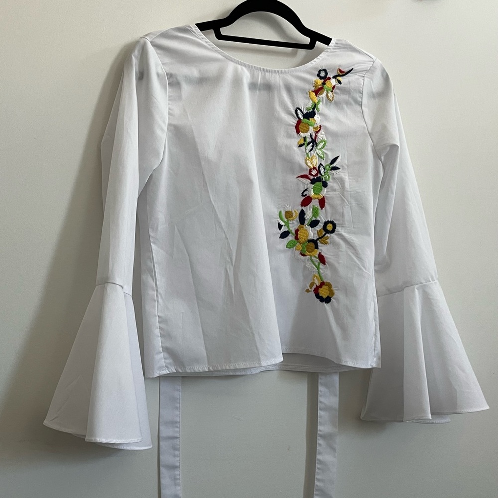 White shirt with bell sleeves, open back and embroidered flowers